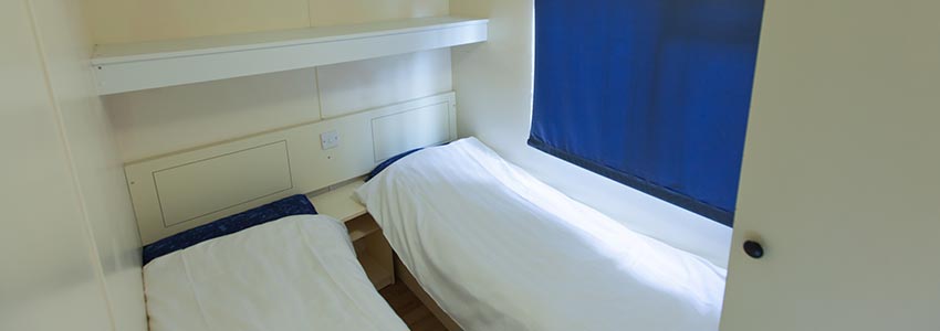 Slaapkamer met twee éénpersoonsbedden in stacaravan budget